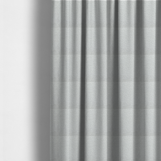 The fabric used to create these made-to-measure curtains is a clean, contemporary light-grey and white weave. It is crafted with a dense, nubby construction that creates a subtle horizontal ribbing effect, providing both visual dimension and a soft, tactile quality.