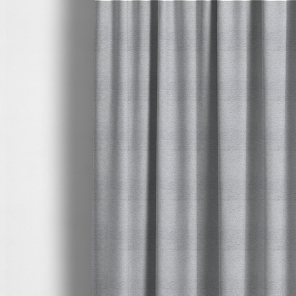 The fabric used to create these made-to-measure curtains is a refined, soft grey and white two-tone weave. It is crafted with a dense, nubby construction that creates a subtle horizontal ribbing effect, offering both visual dimension and a cosy, tactile quality.