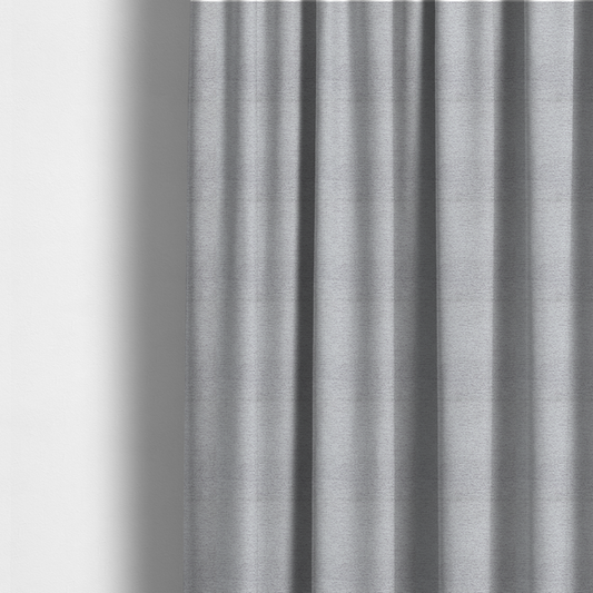 The fabric used to create these made-to-measure curtains is a refined, soft grey and white two-tone weave. It is crafted with a dense, nubby construction that creates a subtle horizontal ribbing effect, offering both visual dimension and a cosy, tactile quality.