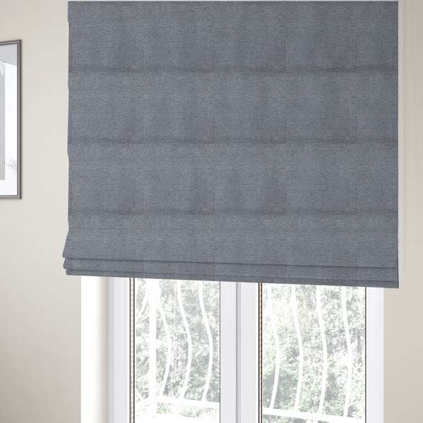 The fabric used to create these Roman blinds is a sophisticated, deep charcoal and slate-grey weave. It features a dense, nubby construction that creates an intricate horizontal ribbing effect, providing significant visual depth and a substantial, inviting tactile quality.