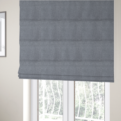 The fabric used to create these Roman blinds is a sophisticated, deep charcoal and slate-grey weave. It features a dense, nubby construction that creates an intricate horizontal ribbing effect, providing significant visual depth and a substantial, inviting tactile quality.
