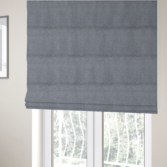 The fabric used to create these Roman blinds is a sophisticated, deep charcoal and slate-grey weave. It features a dense, nubby construction that creates an intricate horizontal ribbing effect, providing significant visual depth and a substantial, inviting tactile quality.