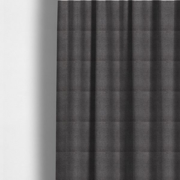 The fabric used to create these made-to-measure curtains is a deep, sophisticated charcoal-grey weave. It is constructed with a dense, nubby texture that creates a subtle, consistent horizontal ribbing effect, providing significant visual depth and a substantial, premium feel.