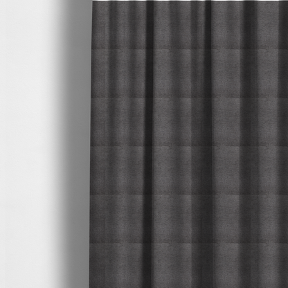 The fabric used to create these made-to-measure curtains is a deep, sophisticated charcoal-grey weave. It is constructed with a dense, nubby texture that creates a subtle, consistent horizontal ribbing effect, providing significant visual depth and a substantial, premium feel.