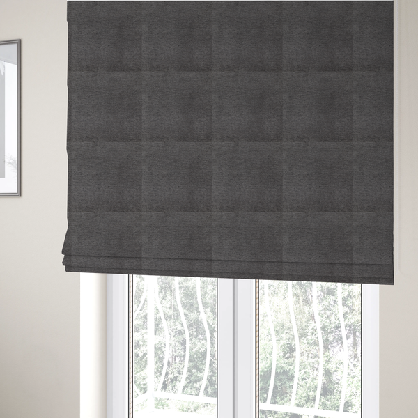 The fabric used to create these Roman blinds is a deep, sophisticated charcoal-grey weave. It is constructed with a dense, nubby texture that creates a subtle, consistent horizontal ribbing effect, providing significant visual depth and a substantial, premium feel.