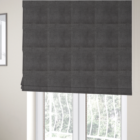 The fabric used to create these Roman blinds is a deep, sophisticated charcoal-grey weave. It is constructed with a dense, nubby texture that creates a subtle, consistent horizontal ribbing effect, providing significant visual depth and a substantial, premium feel.