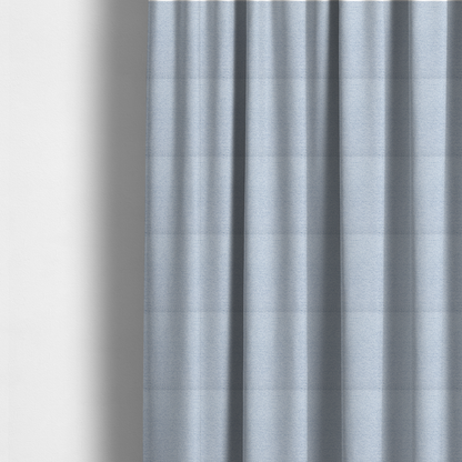 The fabric used to create these made-to-measure curtains is a serene, cool-toned light blue fabric featuring a dense, nubby weave that provides a subtle, calming texture, perfect for adding a touch of tranquil colour and refined style to home upholstery.