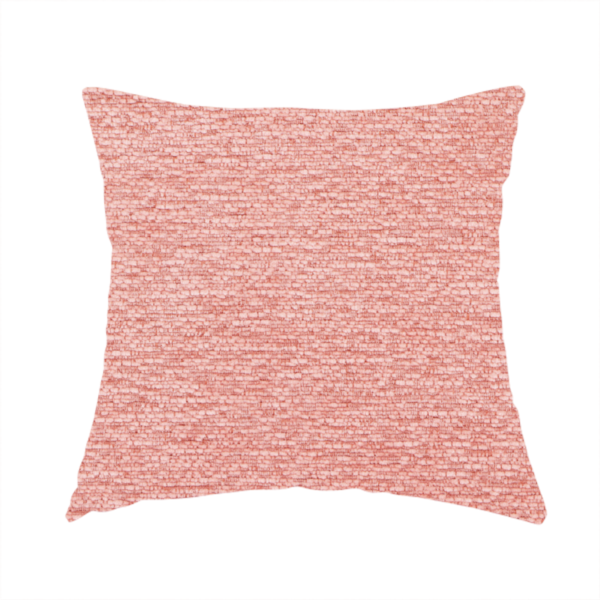 The fabric used to create this handmade cushion is a soft, pastel coral-pink fabric with a dense, nubby textured weave and subtle horizontal ribbing, adding a gentle and welcoming pop of colour to decorative cushions or accent pieces.