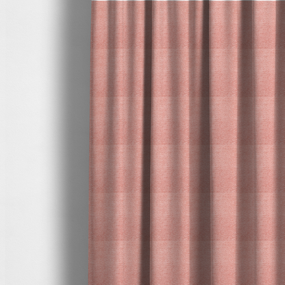 The fabric used to create these made-to-measure curtains is a soft, pastel coral-pink fabric with a dense, nubby textured weave and subtle horizontal ribbing, adding a gentle and welcoming pop of colour to decorative cushions or accent pieces.