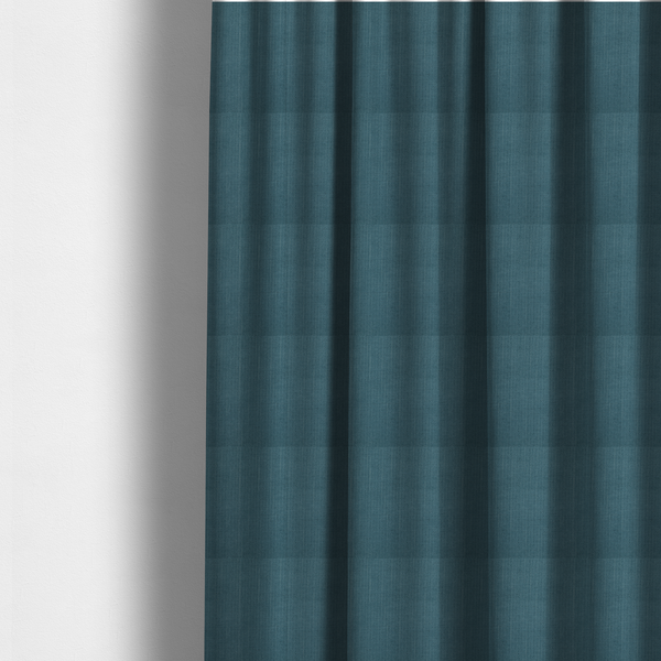 The fabric used to create these made-to-measure curtains is a textured woven fabric in a dusty teal or muted slate blue colour.