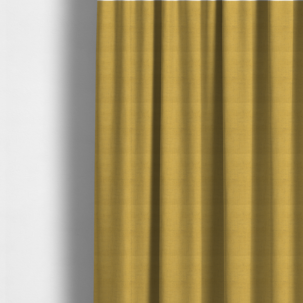 The fabric used to create these made-to-measure curtains is a textured woven fabric in a warm mustard yellow or golden ochre shade.