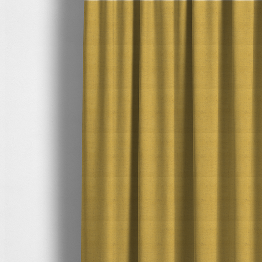 The fabric used to create these made-to-measure curtains is a textured woven fabric in a warm mustard yellow or golden ochre shade.