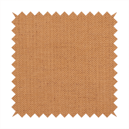 A textured woven fabric in a warm terracotta or soft pumpkin orange shade.