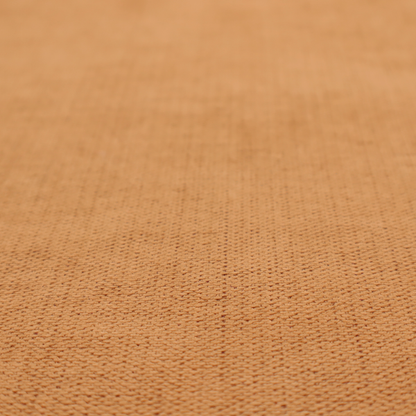 A textured woven fabric in a warm terracotta or soft pumpkin orange shade.