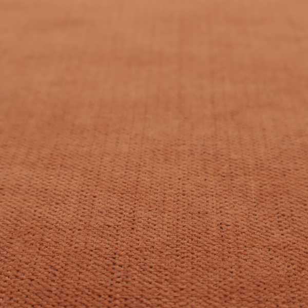 A textured woven fabric in a rich, warm rust or burnt orange shade.