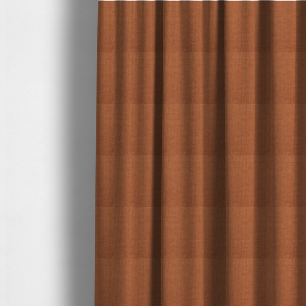 The fabric used to create these made-to-measure curtains is a textured woven fabric in a rich, warm rust or burnt orange shade.