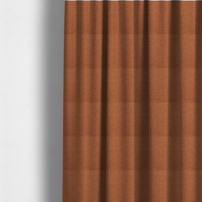 The fabric used to create these made-to-measure curtains is a textured woven fabric in a rich, warm rust or burnt orange shade.