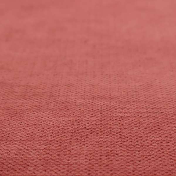 A textured woven fabric in a soft, dusty red or muted brick red shade.