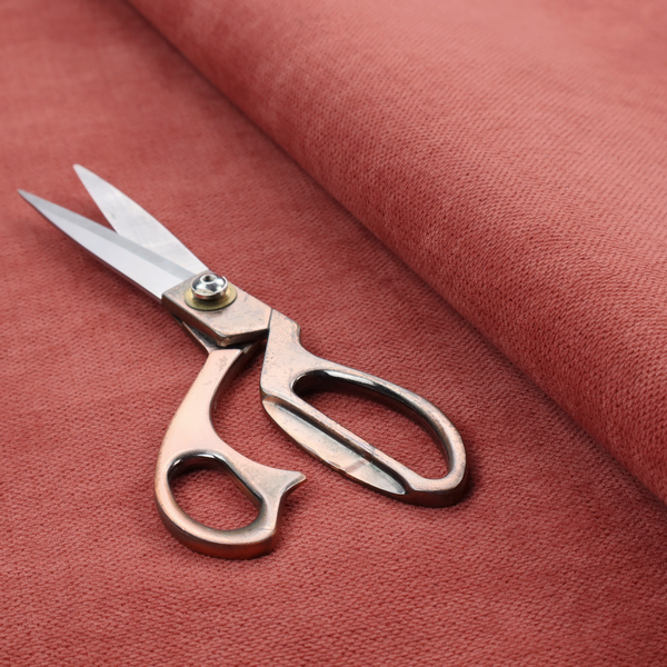 A textured woven fabric in a soft, dusty red or muted brick red shade.