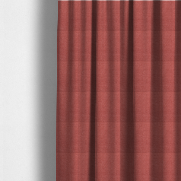 The fabric used to create these made-to-measure curtains is a textured woven fabric in a soft, dusty red or muted brick red shade.