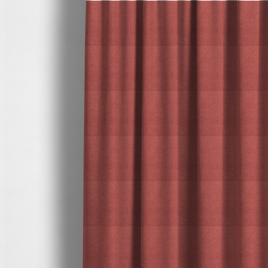 The fabric used to create these made-to-measure curtains is a textured woven fabric in a soft, dusty red or muted brick red shade.