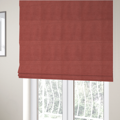 The fabric used to create these Roman blinds is a textured woven fabric in a soft, dusty red or muted brick red shade.