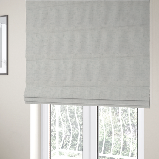 The fabric used to create these Roman blinds is a textured woven fabric in a crisp white or light ivory shade.
