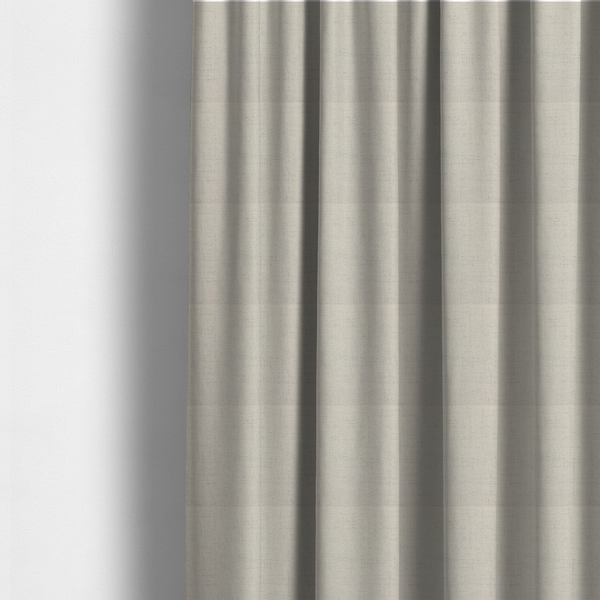 The fabric used to create these made-to-measure curtains is a textured woven fabric in a warm off-white, light cream, or pale beige shade.