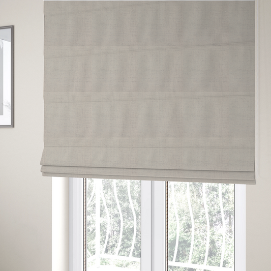 The fabric used to create these Roman blinds is a textured woven fabric in a warm off-white, light cream, or pale beige shade.