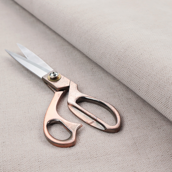 A textured woven fabric in a very pale, dusty blush pink or soft ivory shade with a subtle rosy undertone.
