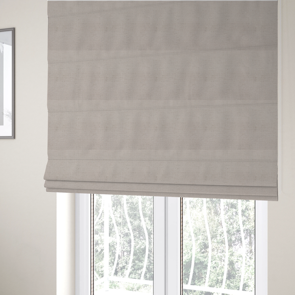 The fabric used to create these Roman blinds is a textured woven fabric in a very pale, dusty blush pink or soft ivory shade with a subtle rosy undertone.