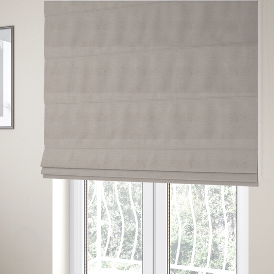 The fabric used to create these Roman blinds is a textured woven fabric in a very pale, dusty blush pink or soft ivory shade with a subtle rosy undertone.