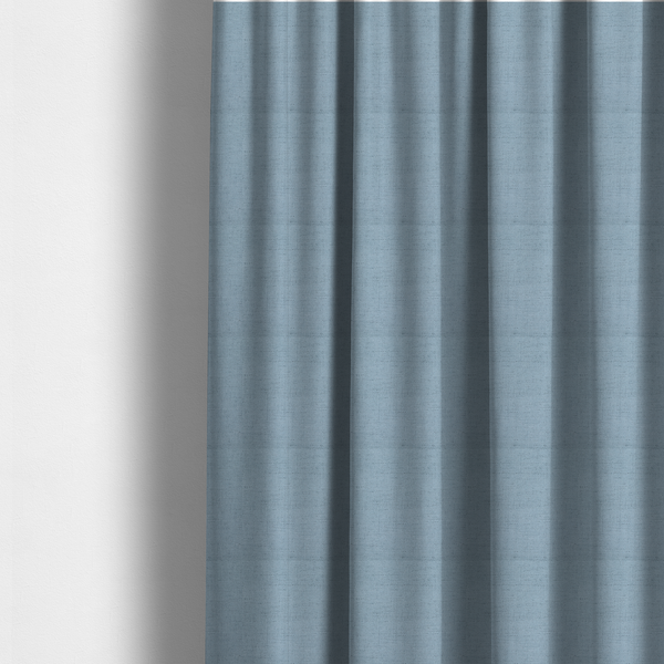 The fabric used to create these made-to-measure curtains is a textured woven fabric in a soft, light powder blue or serene sky blue shade.