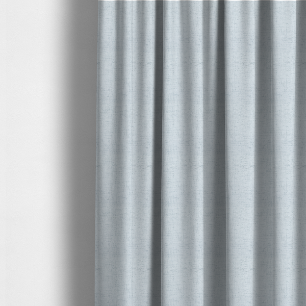 The fabric used to create these made-to-measure curtains is a textured woven fabric in a very pale, icy blue or light mist grey-blue shade.