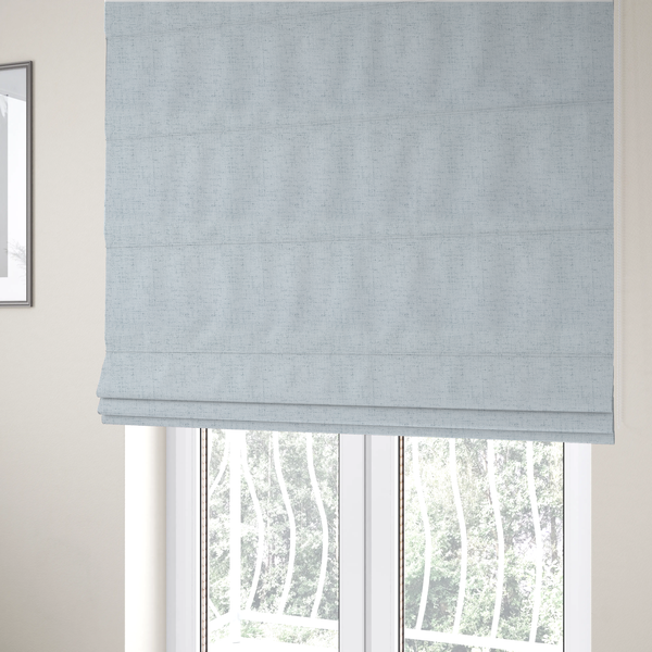 The fabric used to create these Roman blinds is a textured woven fabric in a very pale, icy blue or light mist grey-blue shade.