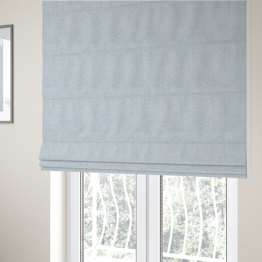 The fabric used to create these Roman blinds is a textured woven fabric in a very pale, icy blue or light mist grey-blue shade.