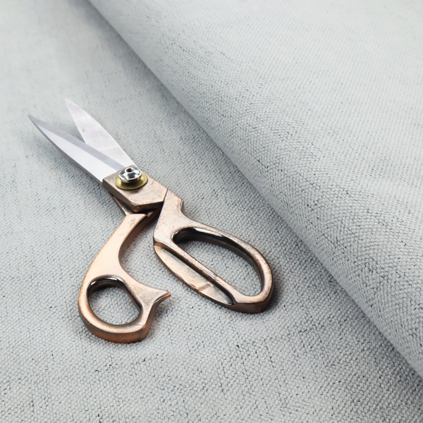 A textured woven fabric in a cool, light grey or soft slate shade.