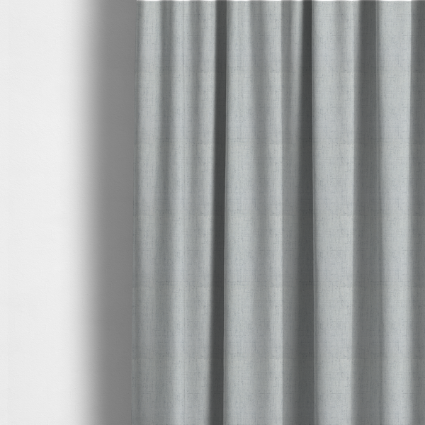 The fabric used to create these made-to-measure curtains is a textured woven fabric in a cool, light grey or soft slate shade.