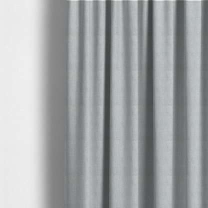 The fabric used to create these made-to-measure curtains is a textured woven fabric in a cool, light grey or soft slate shade.