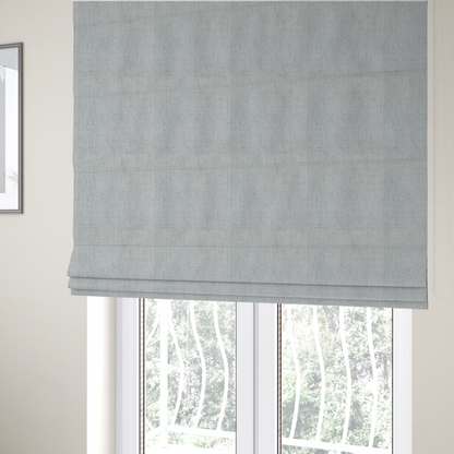 The fabric used to create these Roman blinds is a textured woven fabric in a cool, light grey or soft slate shade.