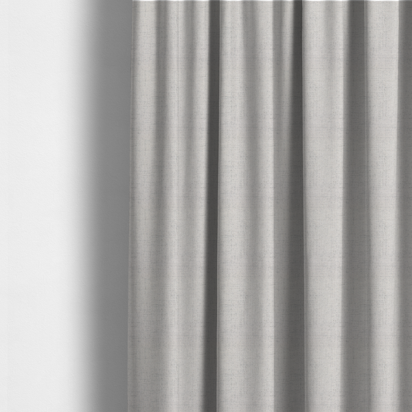 The fabric used to create these made-to-measure curtains is a textured woven fabric in a very light grey or soft ash shade.