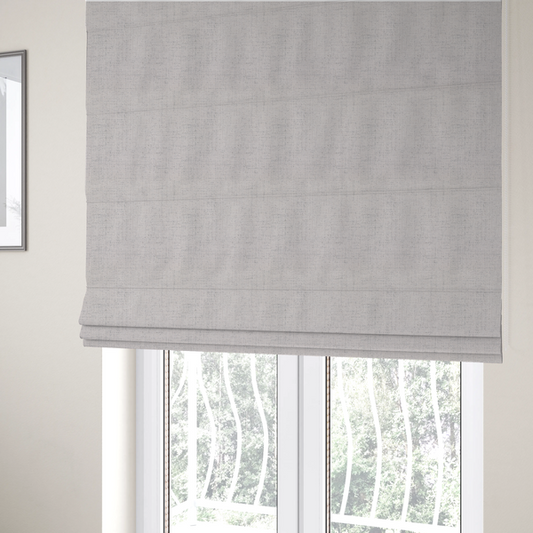 The fabric used to create these Roman blinds is a textured woven fabric in a very light grey or soft ash shade.
