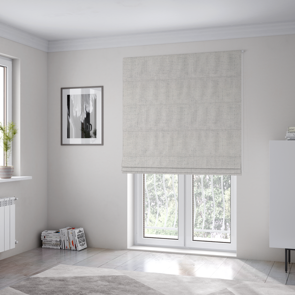 The fabric used to create these Roman blinds is a textured woven fabric in a very light grey or soft ash shade.