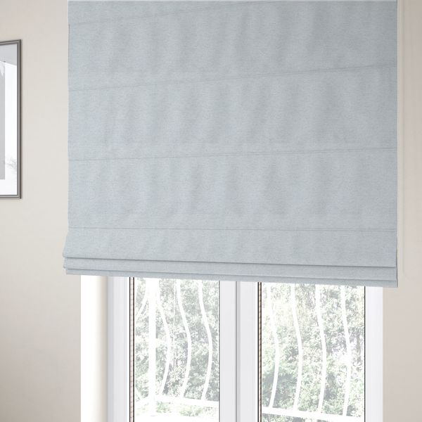 The fabric used to create these Roman blinds is a textured silver woven fabric with a subtle metallic sheen.