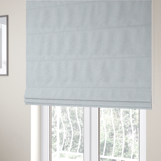 The fabric used to create these Roman blinds is a textured silver woven fabric with a subtle metallic sheen.