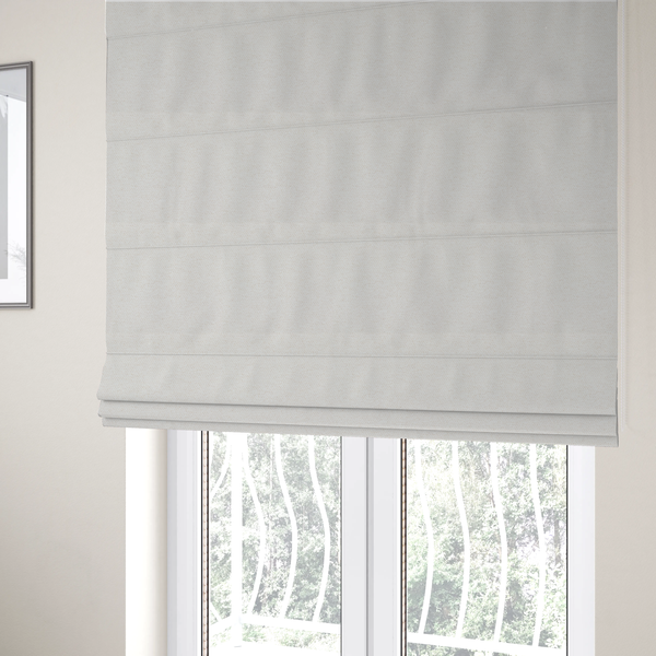 The fabric used to create these Roman blinds is a cream or ivory woven upholstery fabric with a fine, pebble-like texture.