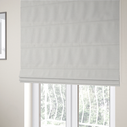 The fabric used to create these Roman blinds is a cream or ivory woven upholstery fabric with a fine, pebble-like texture.