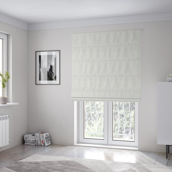 The fabric used to create these Roman blinds is a cream or ivory woven upholstery fabric with a fine, pebble-like texture.