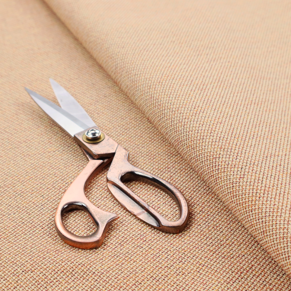 A warm terracotta and peach textile featuring a dense diagonal twill weave. The fabric is a multi-tonal blend of soft orange, muted red, and cream threads, creating a heathered, sun-baked appearance.