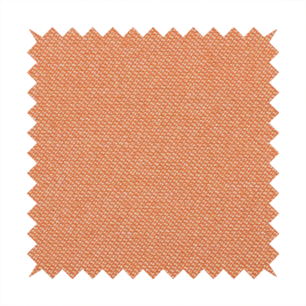 A vibrant apricot or orange textile with a tight diagonal twill weave. The fabric is woven with a primary saturated orange thread interspersed with fine white or cream yarns, creating a bright, textured surface with a subtle "salt and pepper" effect.